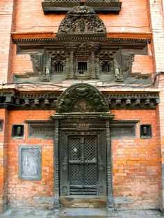 an old brick building with ornate carvings on the front door and side entrance to it