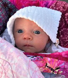 a baby in a car seat with a hat on top of it's head