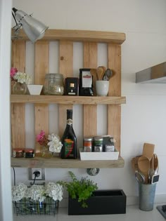 the shelves in the kitchen are made out of wooden pallets and have flowers on them