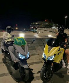 two people are sitting on motorcycles at night