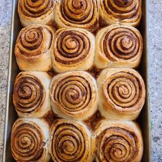 a pan filled with cinnamon rolls sitting on top of a counter