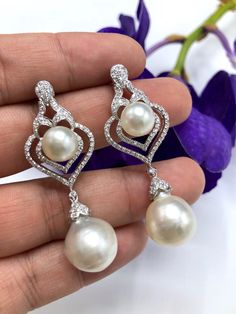 We are presenting you a HUGE pair of CHANDELIER, Genuine, PURE White South Sea Pearls, extremely FINE A+, LUSTROUS and Rare! Accenting the 4 pearls are 136 pieces of E/VS Natural diamonds, weighting a total of 1.62 carats. Set in fabulously designed 18K solid white gold earrings ONLY ONE ITEM AVAILABLE!! NO DUPLICATES!! WHAT YOU SEE IN THE PICTURES IS WHAT YOU WILL GET SOLIDLY HANDCRAFTED EARRINGS! SUGGESTED RETAIL VALUE: $10,880 PEARLS: Size: Bottom Pair 14 x 15 mm, Top Pair 11 mm. Shape: Round Jewellery Luxury, Pearl Chandelier Earrings, Pearl Chandelier, Vvs Diamond, Golden South Sea Pearls, Earrings Handmade Dangle, White Gold Earrings, South Sea Pearls, Sea Pearls