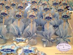 there are many cookies on the table with blue ribbon around them and some candies