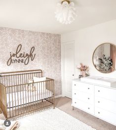 a baby's room with a crib, dresser and mirror