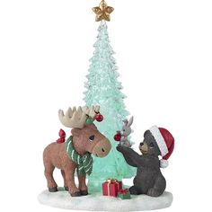 two moose figurines standing next to a christmas tree with presents on it's feet