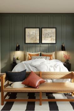 a bedroom with green walls and white bedding, two framed pictures on the wall