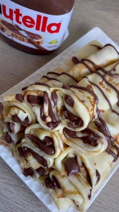 some kind of food that is on a white plate and next to a jar of nutella