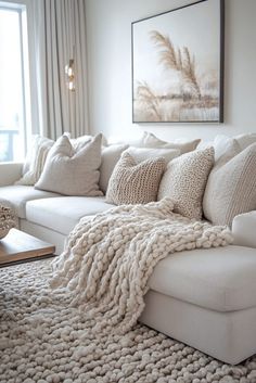 a large white couch sitting in a living room next to a window