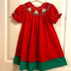 Never Worn But Tag Was Removed Super Pretty Christmas Dress With Wonderful Smocked Details On Collar And Sleeves Could Easily Fit Up To Size 3 Because Of The Traditional Length! Red Embroidered Christmas Dress, Red Embroidered Dress For Christmas, Red Smocked Short Sleeve Dress, Red Short Sleeve Holiday Dress, Red Holiday Dress With Smocked Bodice, Red Smocked Bodice Dress For Holiday, Holiday Dresses With Smocked Back, Red Smocked Dress With Ruffles And Short Sleeves, Pretty Christmas Dresses