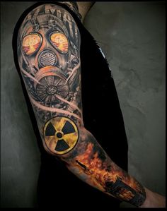 a man's arm with a gas mask tattoo on it and flames coming out of his face