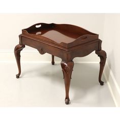 an antique wooden tray with handles and legs on the bottom is sitting in front of a white wall