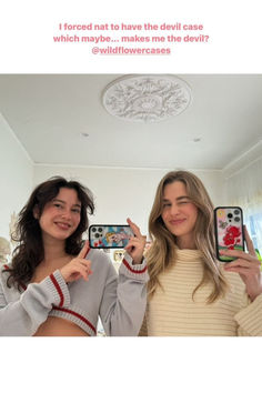 two women holding up their cell phones in front of the camera, with text that reads i forced natt to have the devil case which maybe makes me the devil devil?