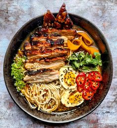 a bowl filled with meat, noodles and vegetables