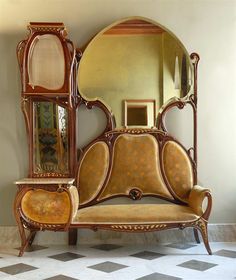 an ornate wooden bed with mirror on the back and side panels, in front of a checkered floor