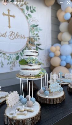 a table topped with cakes and desserts on top of wooden slices covered in frosting