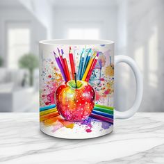 an apple with colored pencils in it on a table