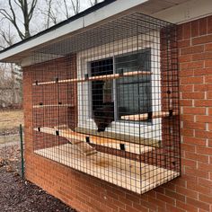 a caged in window on the side of a brick building with wood flooring