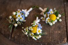 the flowers are arranged on the wooden table for this wedding day bouquets and boutonnieres