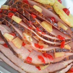 sliced ham with pineapples and bananas on a white plate, ready to be eaten