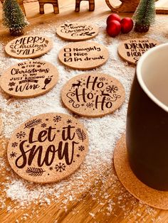 christmas coasters on a table with snow around them