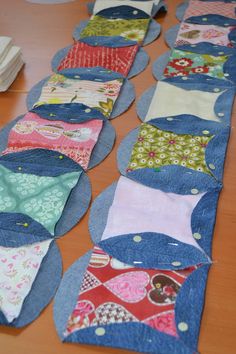 many pieces of fabric are laid out on the table to be sewn quilted