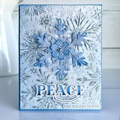 a card with snowflakes on it and the words peace written in blue ink