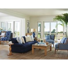 a living room filled with blue furniture and lots of windows covered in glass sliding doors