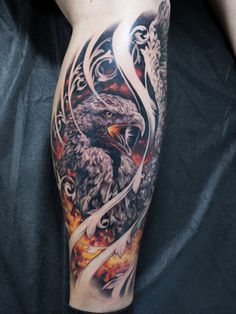 an eagle tattoo on the arm with flames