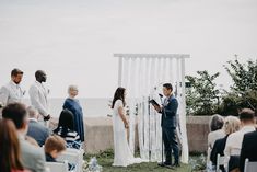 a man and woman standing next to each other in front of an outdoor wedding ceremony