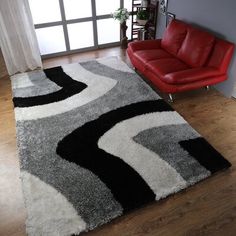 a living room with a red chair and black and white rug