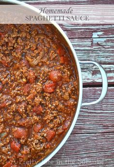 a large pot filled with chili on top of a wooden table