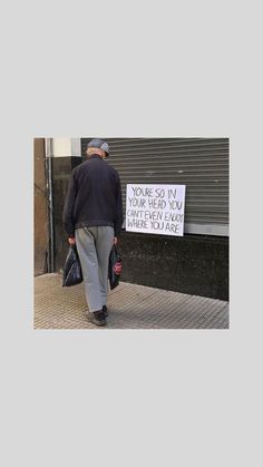 a man is walking down the street with a sign