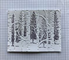 a piece of paper with trees and snow on the ground in front of a grid