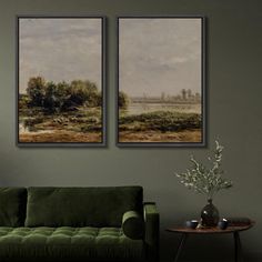 two paintings hang on the wall above a green couch in a room with a table