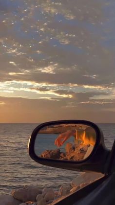 a car's rear view mirror reflecting the ocean