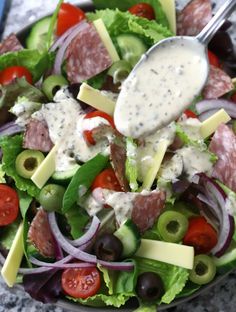 a salad with olives, lettuce, tomatoes, cheese and other toppings