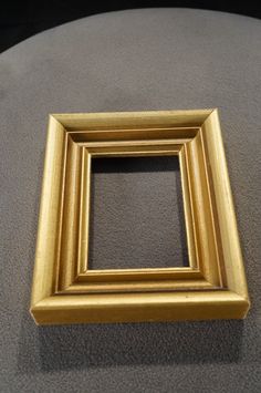 a gold frame sitting on top of a gray surface