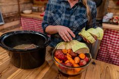 a woman is preparing food in a bowl on a table with a black pot and red checkered table cloth