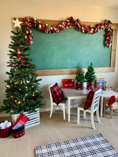 a christmas tree is in front of a chalkboard with red and white plaid decorations