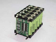 four green and black batteries stacked on top of each other in front of a white background