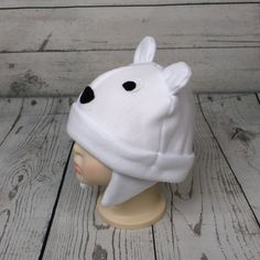 "Baby and Kids Polar Bear Fleece Hat This is a polar bear hat made from white fleece. It features felt eyes, felt nose, and fleece ears. Hat Sizes: Baby: Approx. 20\" around Child: Approx. 22\" around Youth: Approx. 23 1/2\" around Hat shown is a child size on a 18 1/2\" (47cm) head. Care: Machine wash on cool or warm; dry on low. Turnaround time is 1-3 business days. Standard Shipping is usps first class (3-5 business days). Upgrade to priority (2-3 day) and priority express (1-2 day) is availa White Outdoor Beanie Cap, Warm White Beanie For Outdoor, Playful White Bonnet For Winter, Playful White Winter Bonnet, Cute White Cap Bonnet, Playful Warm White Hat, White Warm Beanie Bonnet, Playful Warm White Beanie, Playful White Beanie One Size Fits Most