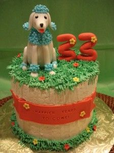 a birthday cake for someone's 30th birthday with a dog on top and flowers around the edges