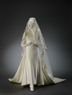 a white wedding dress and veil on display