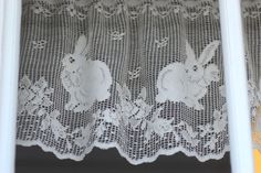 an image of a window curtain with white lace on it's edge and rabbits in the center