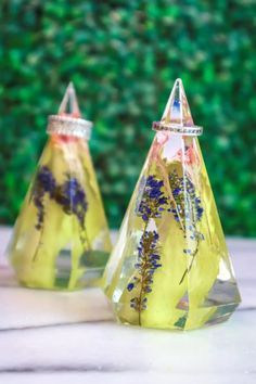 two yellow glass vases with flowers on them