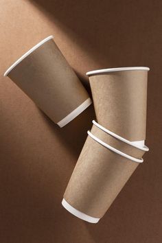 three brown paper cups are stacked on top of each other