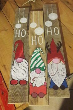 three painted wooden signs with gnomes on them