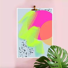 a pink and green abstract painting on a wall next to a potted palm plant