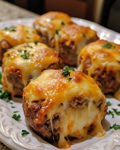 a white plate topped with cheese covered meatballs