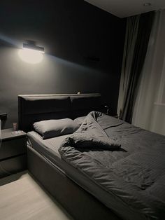 a bed sitting in a bedroom next to a window with a lamp on top of it